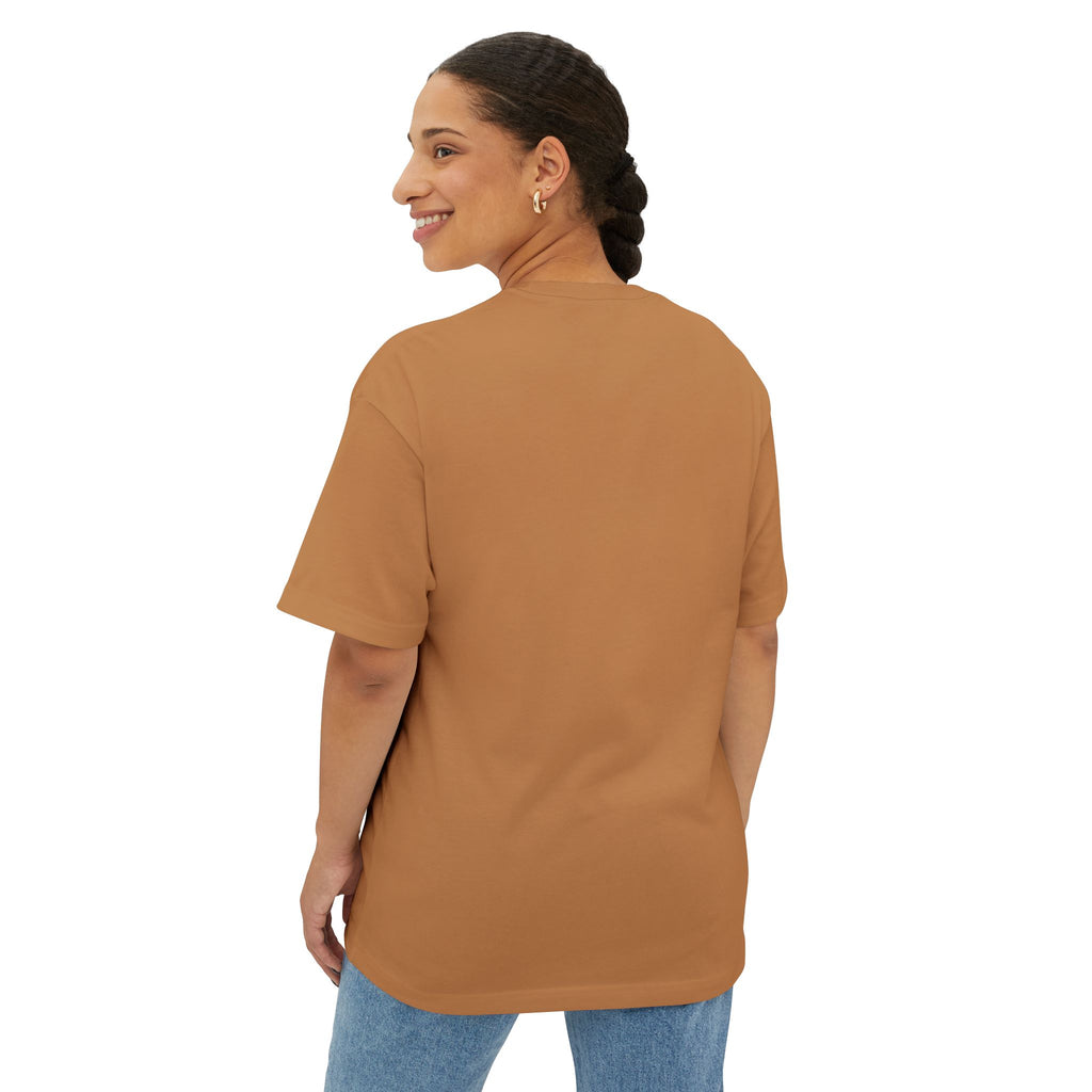 A woman with braided hair smiles back at the camera while wearing the Crowned In Every Era Unisex Oversized Boxy Tee and blue jeans, standing against a white background.