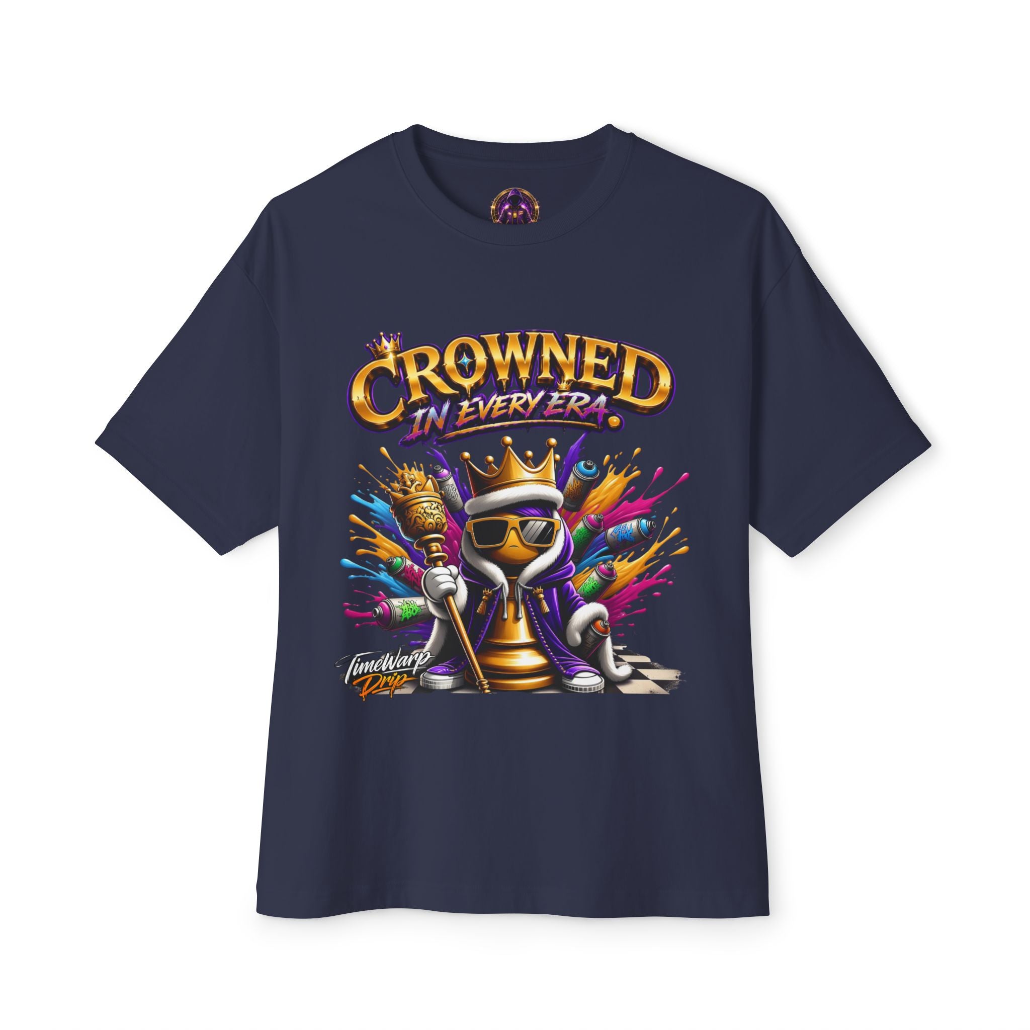 The "Crowned In Every Era" Unisex Oversized Boxy Tee is navy blue, 100% airlume cotton, relaxed fit, and features a cartoon chess king with sunglasses, crown, and scepter amid colorful splashes with "CROWNED IN EVERY ERA" above the design.