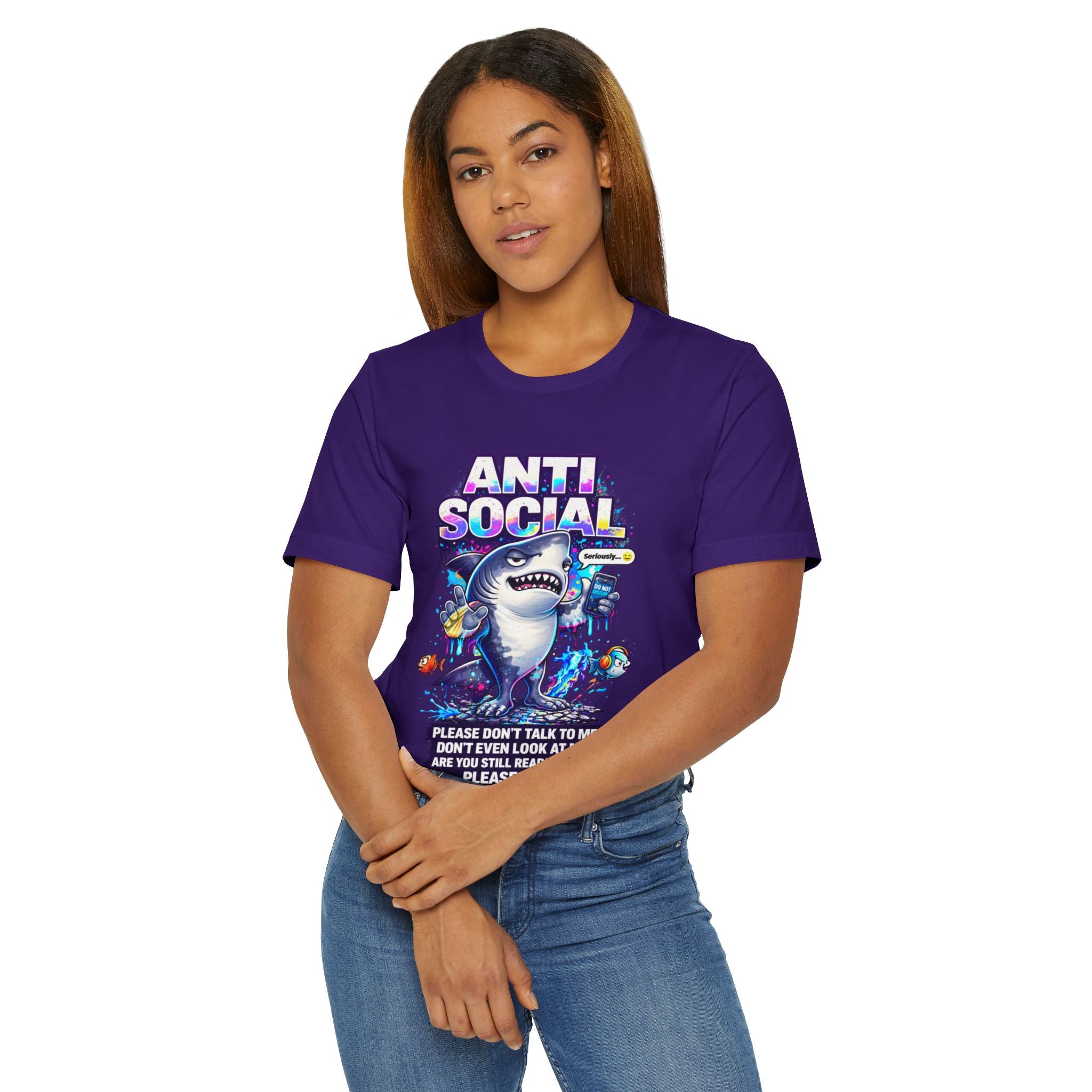 A woman with straight brown hair wears the Anti Social Shark T-Shirt — Funny Introvert Graphic Tee, a purple unisex cotton shirt featuring a cartoon shark, colorful graphics, and the phrase: Please don't talk to me, don't even look at me—just let me exist.