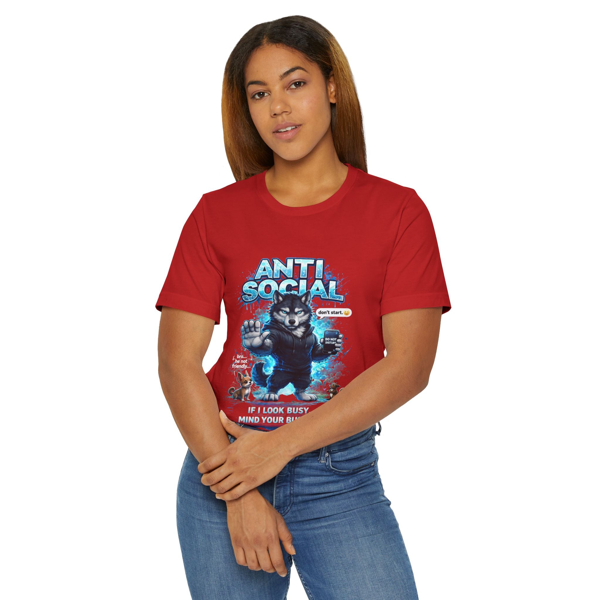 A woman with straight brown hair wears the Timewarp Drip Anti Social Wolf T-Shirt—Funny Introvert Graphic Tee featuring a grumpy wolf, bold blue graffiti ANTI SOCIAL text, and “If I look busy, mind your business” on white.