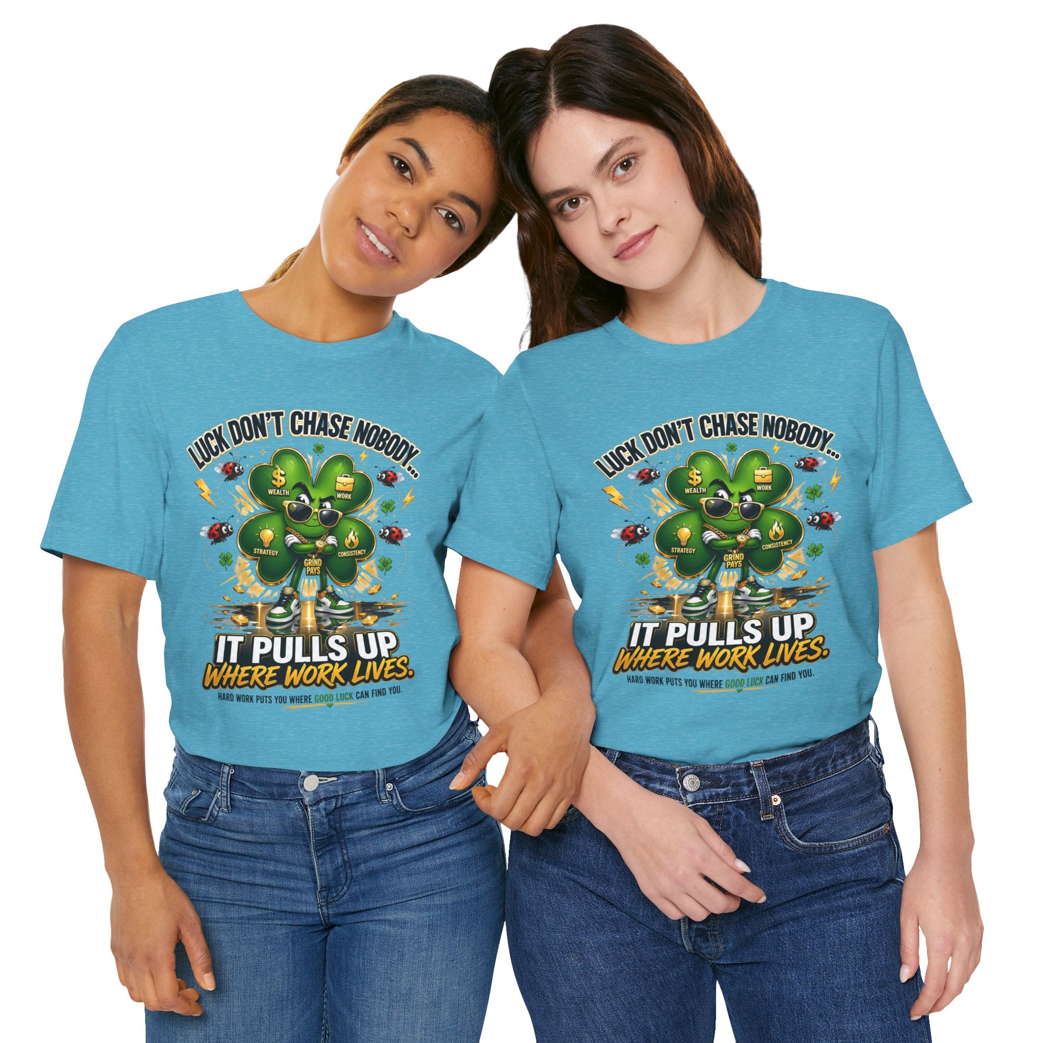 Two women smile side by side, each in a TimeWarp Drip Lucky Clover “Pulls Up Lives” Graphic T-Shirt (S–3XL) featuring a clover and the text: “Luck doesn’t chase nobody. It pulls up where work lives.” They have an arm around each other.