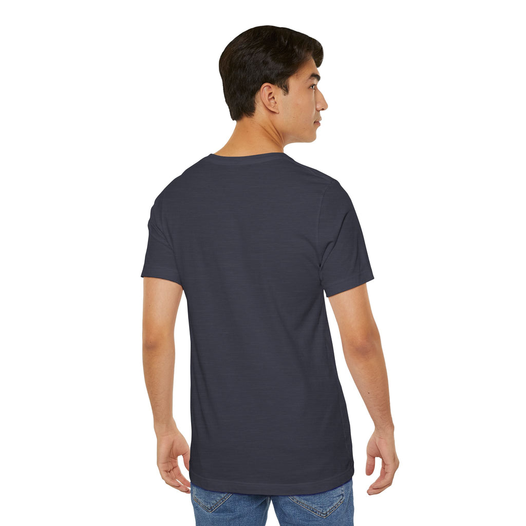 A young man with short dark hair, dressed in the Anti Social Shark T-Shirt — Funny Introvert Graphic Tee and blue jeans, faces away from the camera against a plain white background, glancing slightly to his right.