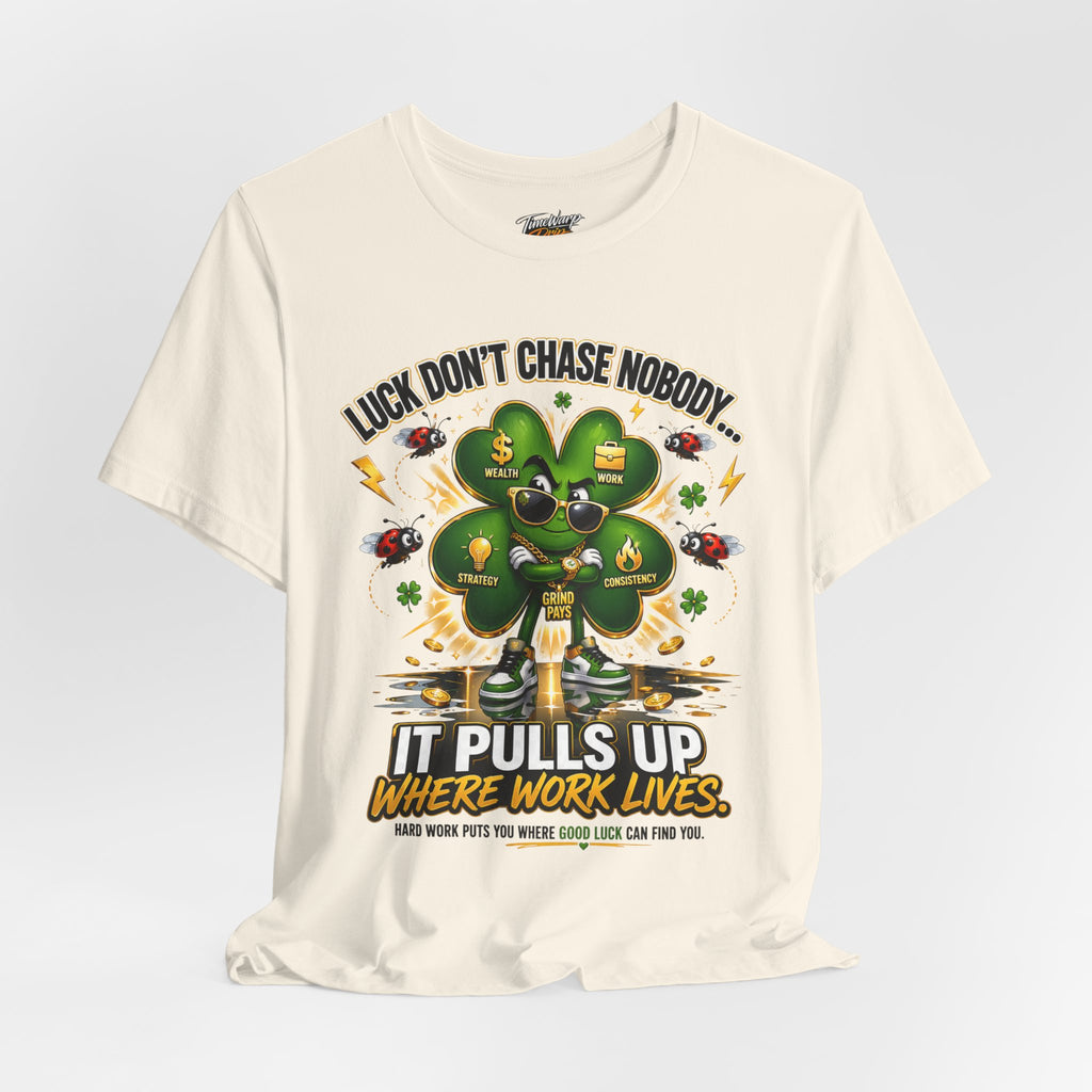 The TimeWarp Drip "Lucky Clover, Pulls Up Lives" Graphic T-Shirt features a stylish clover with sunglasses and gold chains. Available in S-3XL, it reads: “Luck don’t chase nobody! It pulls up where work lives. Hard work puts you where good luck can find you.”.