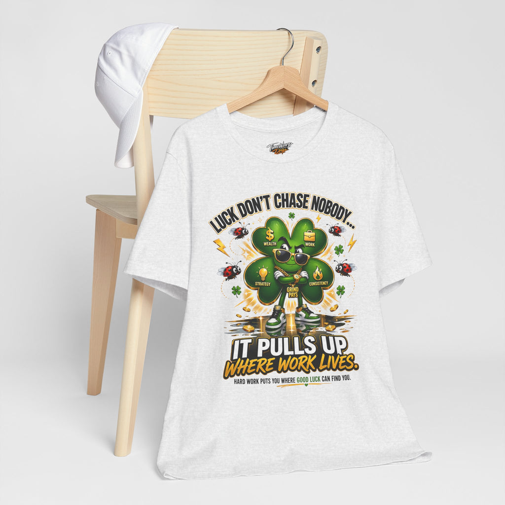 TimeWarp Drip Printify black “Luck Don’t Chase Nobody” streetwear tee drips on chair, white cap flexing tough by its side—clover power vibe. streetwear apparel
