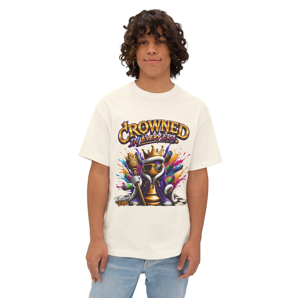 A young person with curly hair wears the "Crowned In Every Era - Unisex Oversized Boxy Tee," a relaxed fit white shirt with a colorful crowned chess piece graphic and the text “CROWNED IN EVERY ERA,” standing against a plain white background.