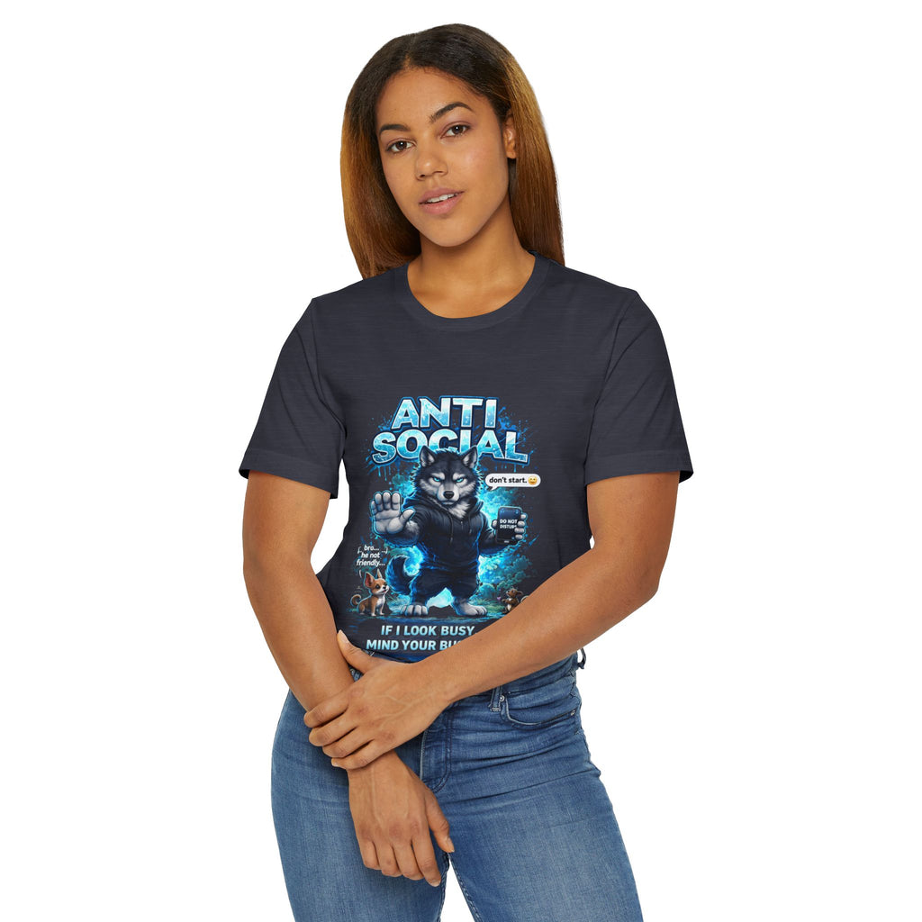 A woman with long, straight hair wears jeans and the Timewarp Drip Anti Social Wolf T-Shirt—a funny introvert graphic tee featuring a grumpy wolf, blue accents, and the text: “ANTI SOCIAL, GO AWAY. IF I LOOK BUSY, MIND YOUR BISCUITS.”.