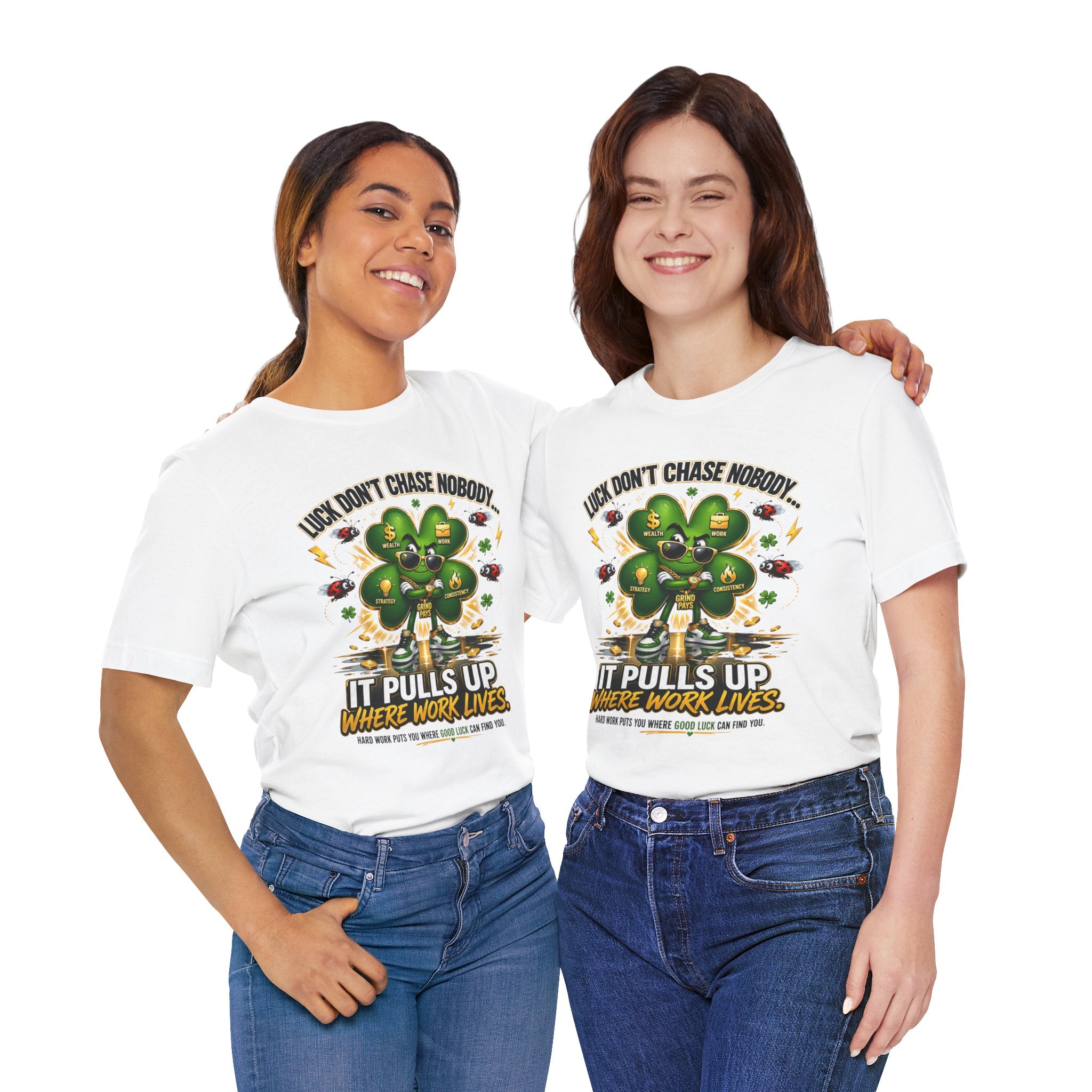 Two women smile side by side in TimeWarp Drip's Lucky Clover "Pulls Up Lives" Graphic T-Shirt—white with green clover and the quote "Luck don’t chase nobody, it pulls up where work lives." Available in S–3XL.