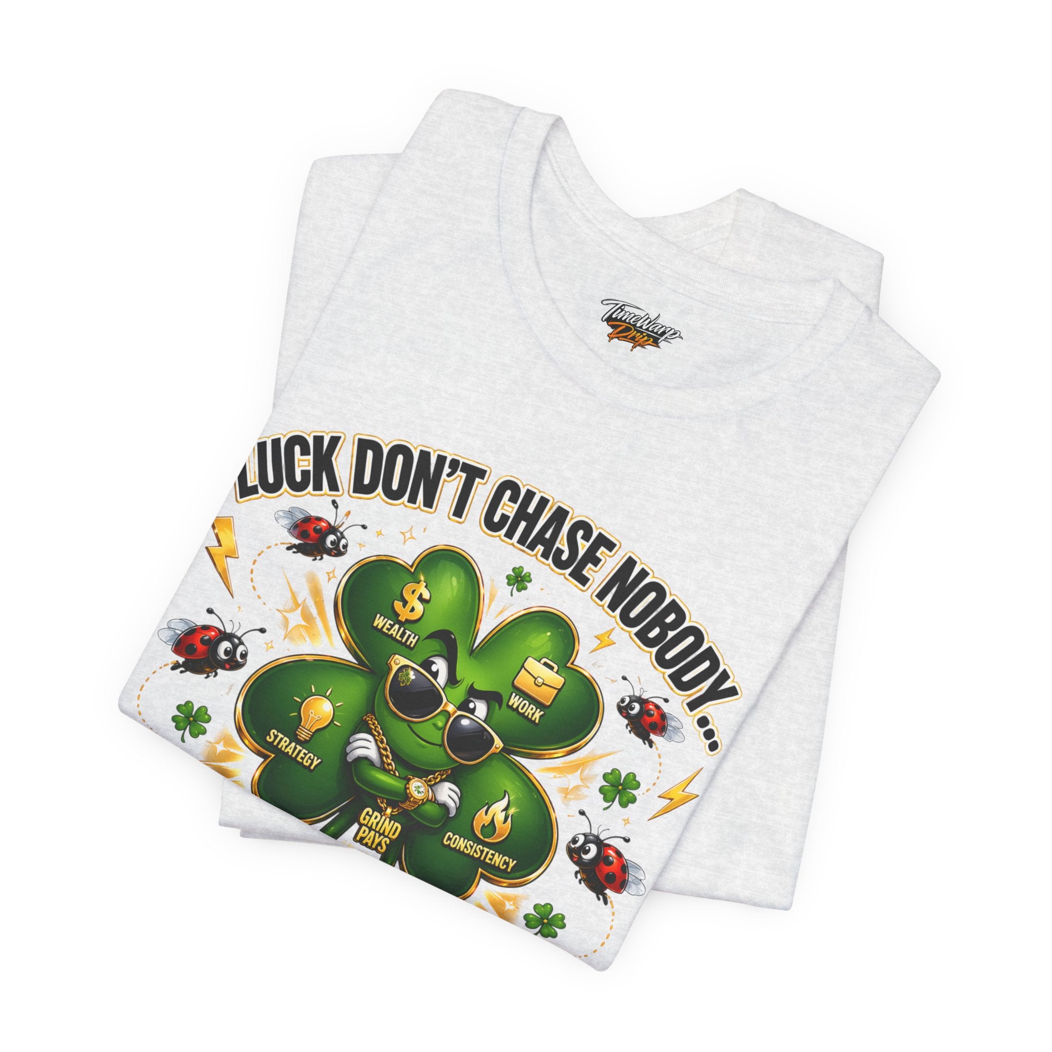 The Lucky Clover "Pulls Up Lives" Graphic T-Shirt by TimeWarp Drip, in light gray (sizes S-3XL), features a sunglasses-clad four-leaf clover with gold chains and "Luck Dont Chase Nobody..." amid gold coins, ladybugs, and lightning bolts.