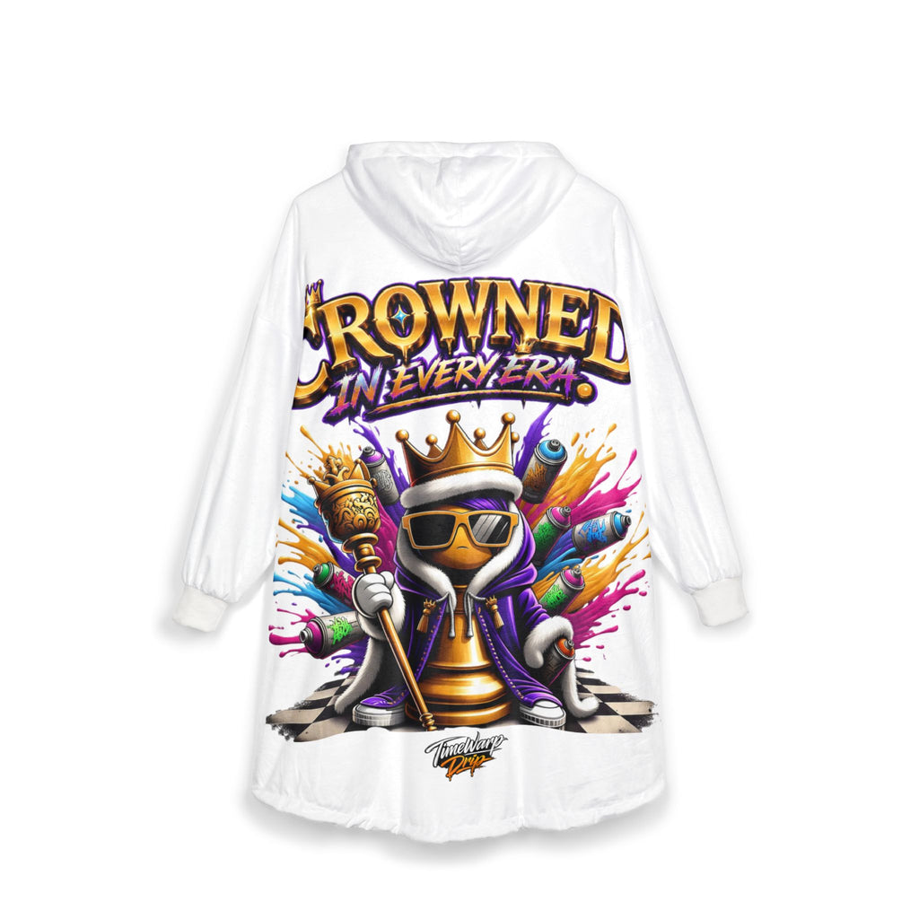 The "Crowned in Every Era" Royal Chess Graphic White Hooded Blanket features a colorful king piece with sunglasses, scepter, and paintbrush, with the phrase above. Paint splashes accent the background and the stylish sleeve-length design.