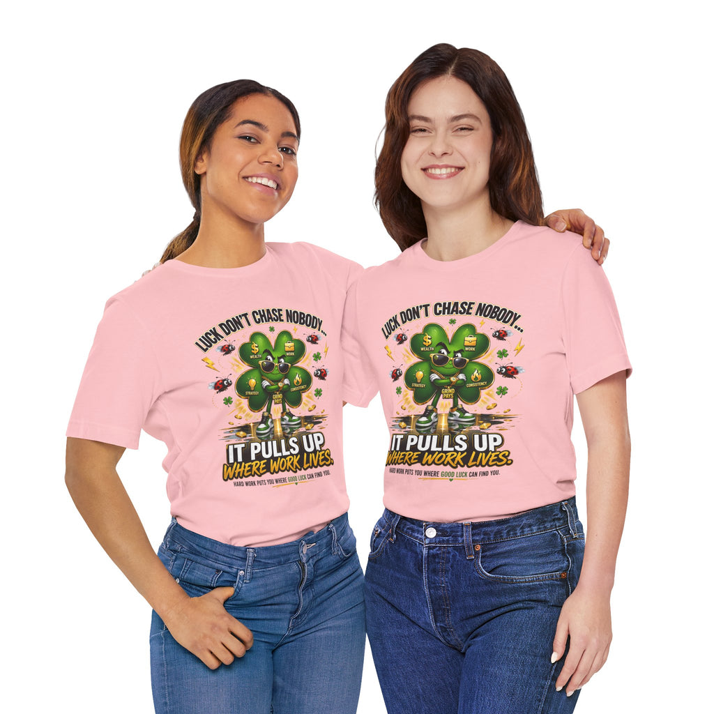 Two women stand side by side, smiling in TimeWarp Drip's "Lucky Clover, Pulls Up Lives" T-shirts (S-3XL), featuring a green clover graphic with the phrase: Luck don’t chase nobody. It pulls up where work lives.