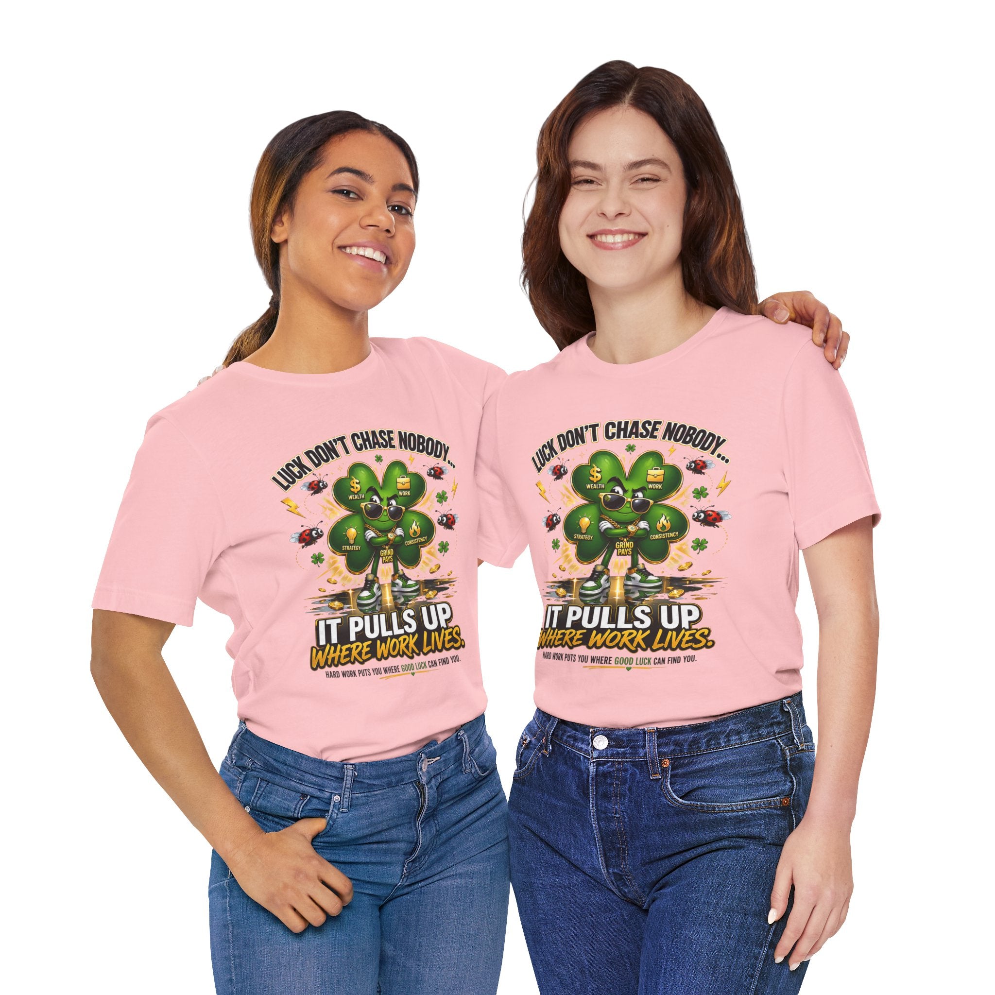 Two women stand side by side, smiling in TimeWarp Drip's "Lucky Clover, Pulls Up Lives" T-shirts (S-3XL), featuring a green clover graphic with the phrase: Luck don’t chase nobody. It pulls up where work lives.
