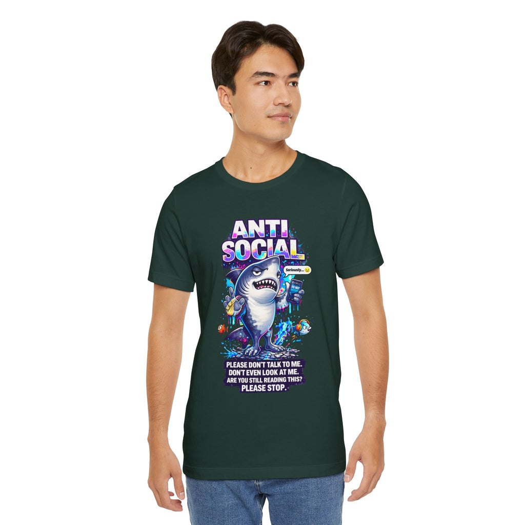 A young man wears the Anti Social Shark T-Shirt — Funny Introvert Graphic Tee, featuring a cartoon shark, colorful sea creatures, and the phrases: ANTI-SOCIAL and “Please don’t talk to me. Don’t even look at me. Are you still reading this? Please stop.”.