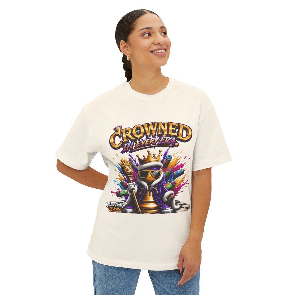 A person smiles and looks up while wearing the Crowned In Every Era - Unisex Oversized Boxy Tee, featuring a relaxed fit, colorful crowned cartoon artwork with sunglasses and spray cans, plus the text "Crowned in Every Era" above.