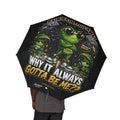 A person holds the Foldable Umbrella — 'Rain? Go Away' Frog Cartoon Waterproof (Black) Travel Umbrella, featuring frogs in rain gear and bold phrases like "WHY IT ALWAYS GOTTA BE ME??" and "RAIN RAIN… GO AWAY!.