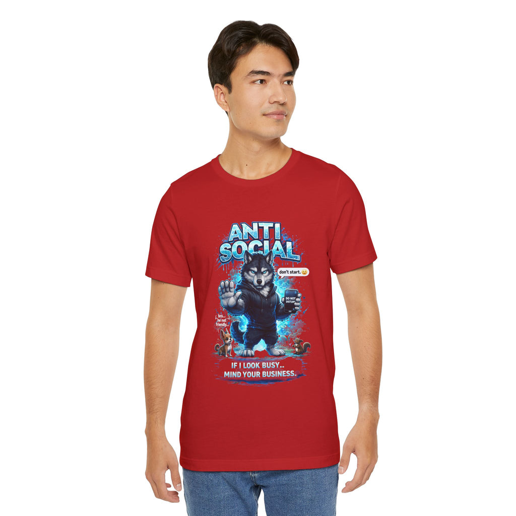 A young man wears the TimeWarp Drip Anti Social Wolf T-Shirt, a funny introvert graphic tee with a wolf in headphones and sunglasses, reading ANTI SOCIAL, Don't talk to me, and If I look busy, mind your business. He stands slightly turned to the side.