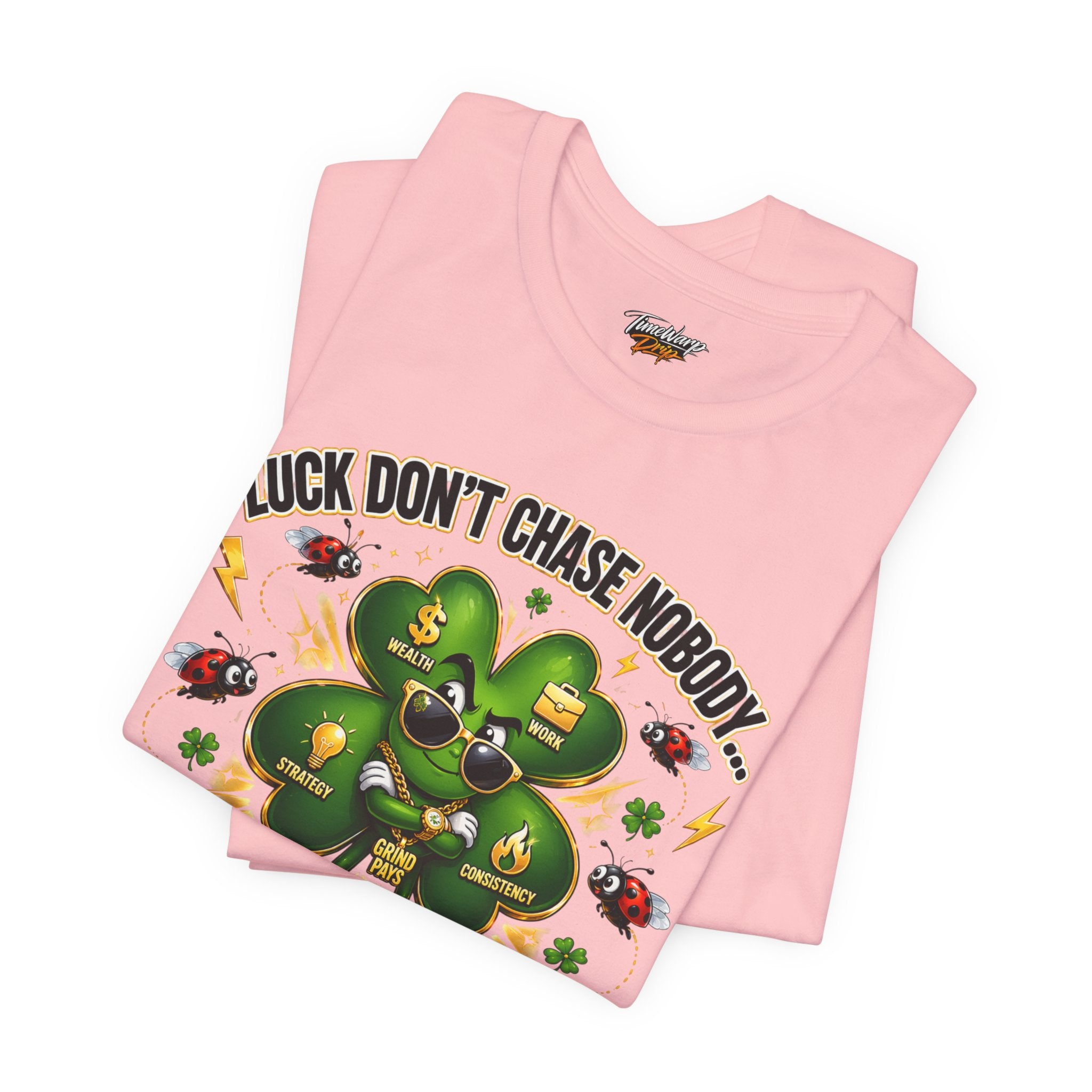 The Lucky Clover "Pulls Up Lives" Graphic T-Shirt by TimeWarp Drip, available in S-3XL pink, showcases a four-leaf clover with sunglasses, ladybugs, gold coins, “LUCK DON’T CHASE NOBODY,” and icons for wealth, strategy, grind & consistency.