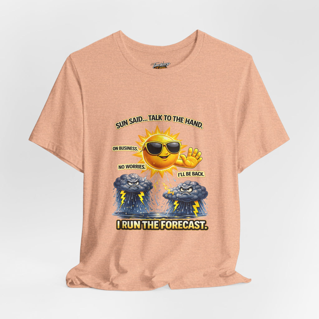The Calm Energy Vibes T-Shirt by Printify features a peach color, smiling sun in sunglasses with CEO Energy and fuming storm clouds below. Airlume cotton. Text: "Sun said... Talk to the hand. On business. I run the forecast.