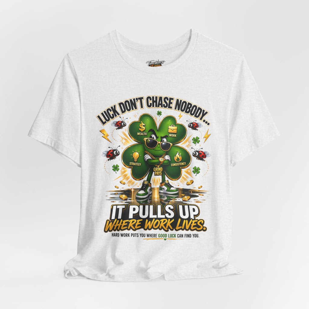The TimeWarp Drip Lucky Clover "Pulls Up Lives" Graphic T-Shirt is a white tee in sizes S-3XL, with a cartoon four-leaf clover in sunglasses and chains, coins and ladybugs, and the text: Luck don’t chase nobody... It pulls up where work lives.
