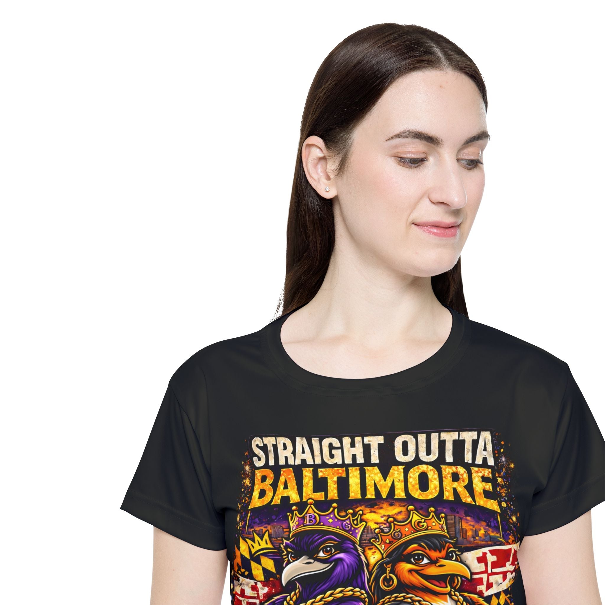 A woman with straight brown hair smiles down, wearing the TimeWarp Drip Straight Outta Baltimore Women's Sports Jersey—a black Charm City fan tee featuring crowned cartoon Baltimore birds.