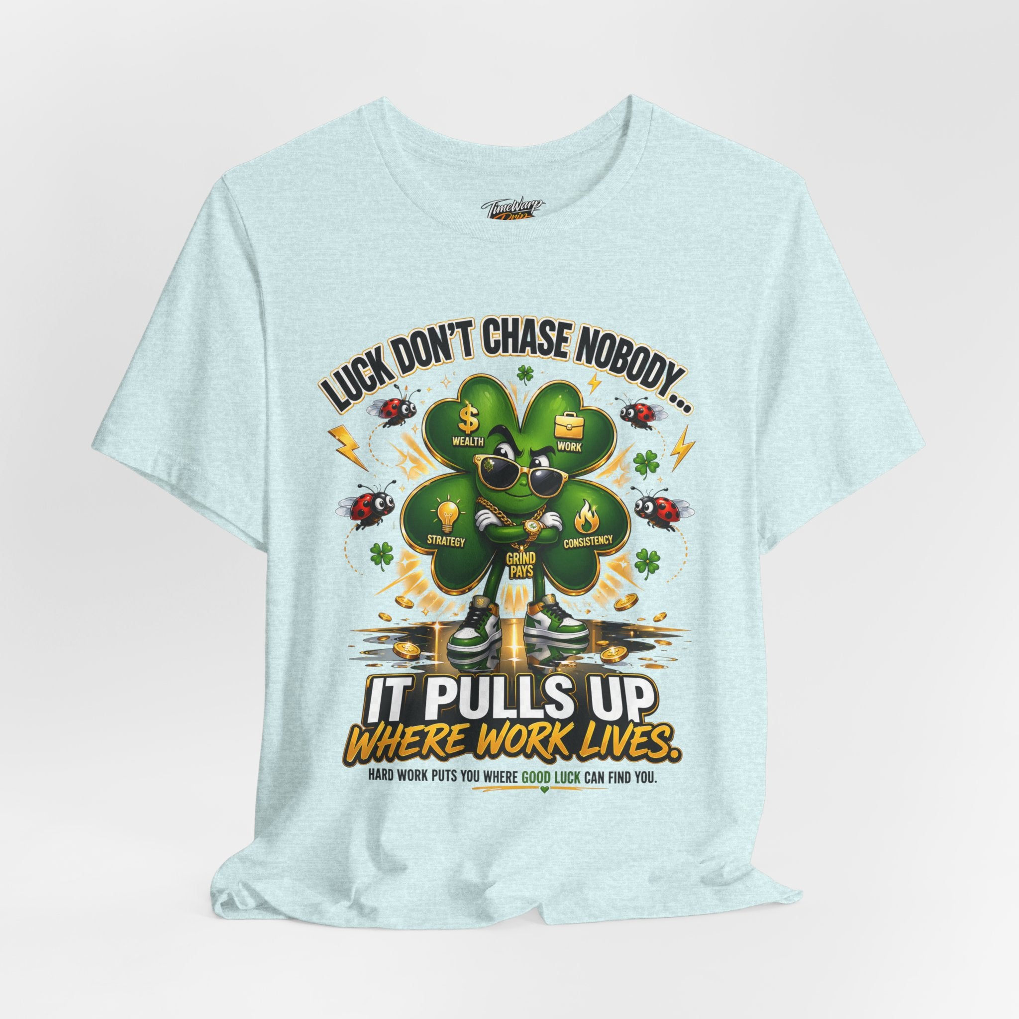 The TimeWarp Drip Lucky Clover "Pulls Up Lives" Graphic T-Shirt in light blue, available in S-3XL, features a cartoon clover with sunglasses and money plus the motivational text: “Luck don’t chase nobody… It pulls up where work lives.”.