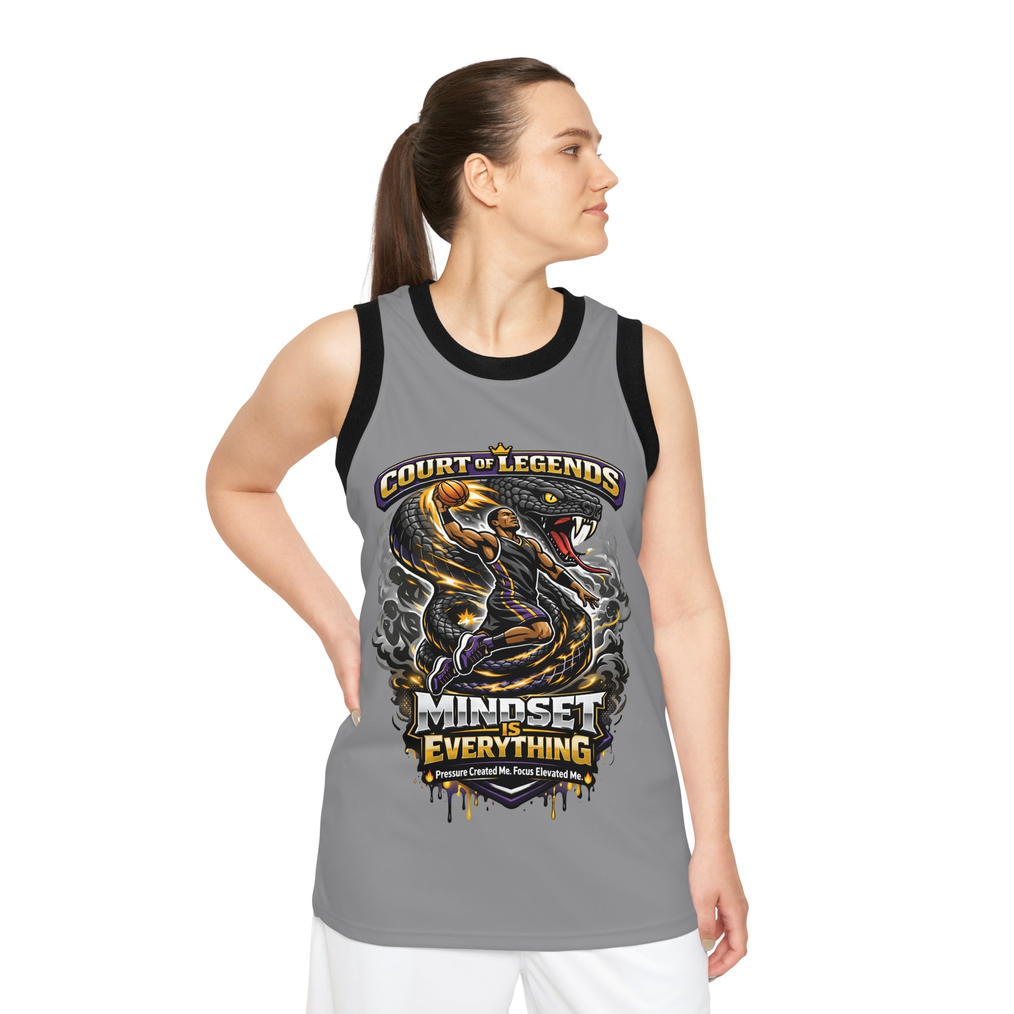 A woman stands with one hand on her hip, looking left, wearing the Court of Legends - (Grey) Basketball Jersey featuring a moisture-wicking polyester design and a player graphic with "Court of Legends" above and "Mindset is Everything" below.