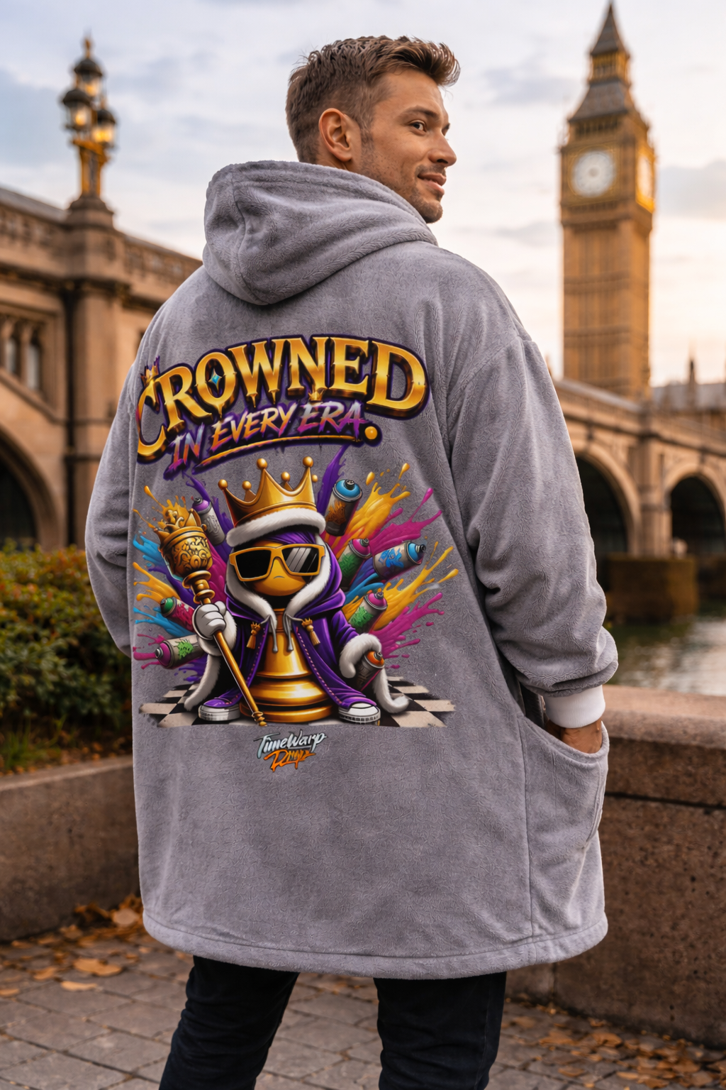 TimeWarp Drip Dripped out in a gray "Crowned in Every Era" Printify hooded blanket, dude flexes streetwear vibes by Big Ben, London. streetwear apparel