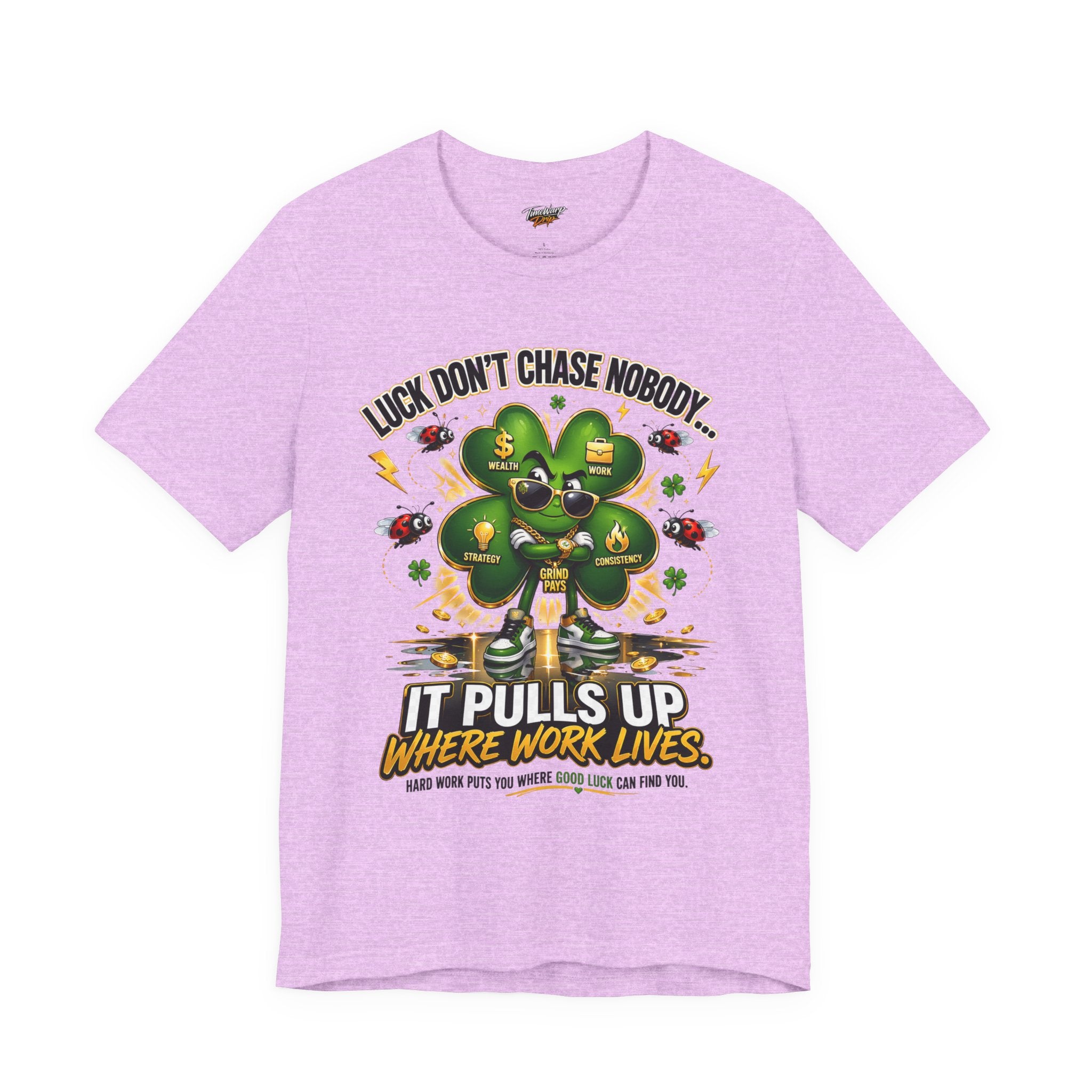 The  Lucky Clover "Pulls Up Lives" Graphic T-Shirt, available in S–3XL light purple, features a four-leaf clover and lucky charms with the message: “Luck don’t chase nobody... Hard work puts you where good luck can find you.”.