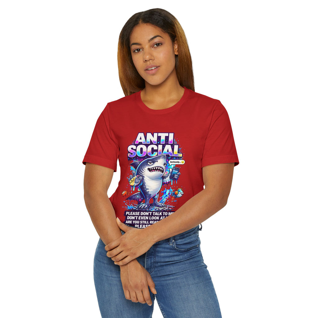 A woman with long brown hair wears the Anti Social Shark T-Shirt — Funny Introvert Graphic Tee, which features a shark graphic and the phrase "Please don't talk to or look at me and we'll both be real," standing against a white background.