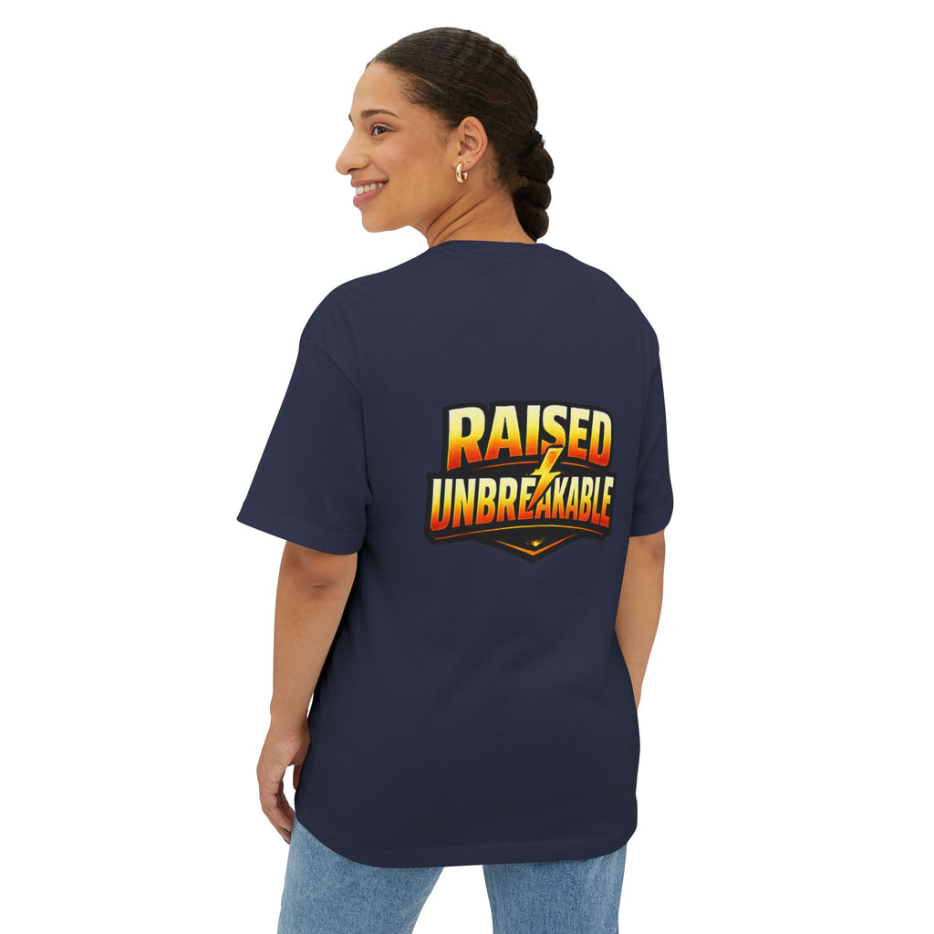 A woman with braided hair smiles as she looks over her shoulder, wearing TimeWarp Drip's Generation X Parenting "Come Get Em" oversized boxy navy tee, made from breathable cotton and featuring bold, gradient yellow-orange "RAISED UNBREAKABLE" text on the back.