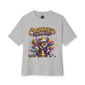 The Crowned In Every Era - Unisex Oversized Boxy Tee is a gray, relaxed fit shirt made of 100% airlume cotton. Features a cartoon king chess piece with sunglasses, crown, and scepter amid colorful splashes and the text "CROWNED IN EVERY ERA.