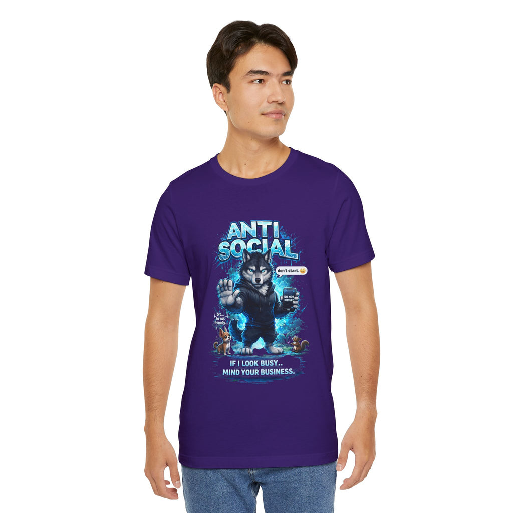 A young man wears a TimeWarp Drip Anti Social Wolf T-Shirt—Funny Introvert Graphic Tee in purple, with a grumpy wolf and "IF I LOOK BUSY... MIND YOUR BUSINESS" caption—as he stands against a white background, looking to the side.