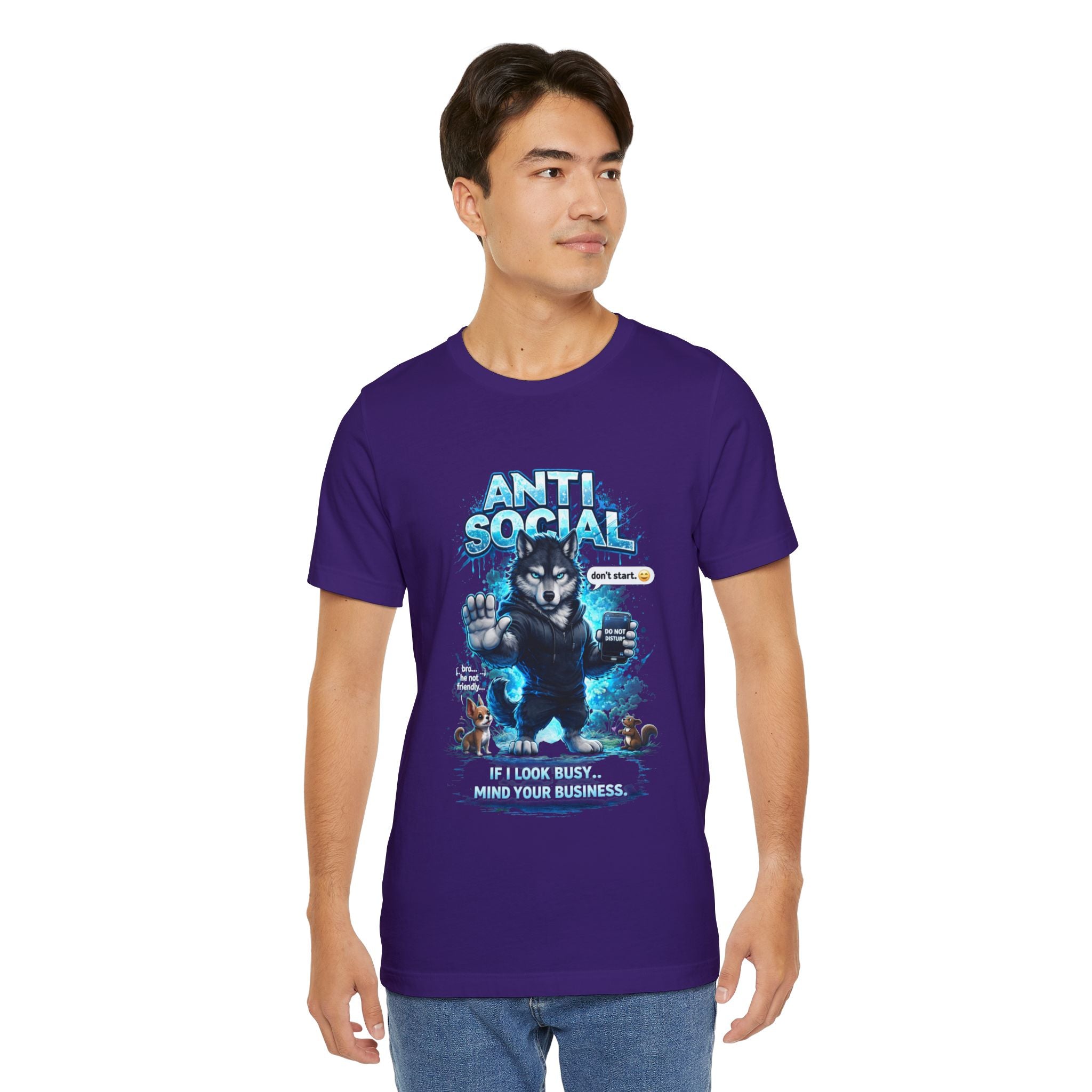 A young man wears a TimeWarp Drip Anti Social Wolf T-Shirt—Funny Introvert Graphic Tee in purple, with a grumpy wolf and "IF I LOOK BUSY... MIND YOUR BUSINESS" caption—as he stands against a white background, looking to the side.