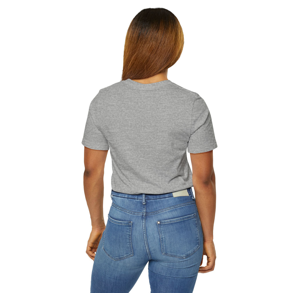 A woman with straight brown hair faces away, wearing the Anti Social Shark T-Shirt — Funny Introvert Graphic Tee in gray and blue jeans with pockets, standing against a plain white background.