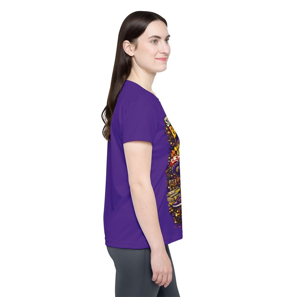 A woman with long brown hair stands sideways, smiling, wearing a purple Straight Outta Baltimore — Women's Sports Jersey and gray pants against a plain white background.