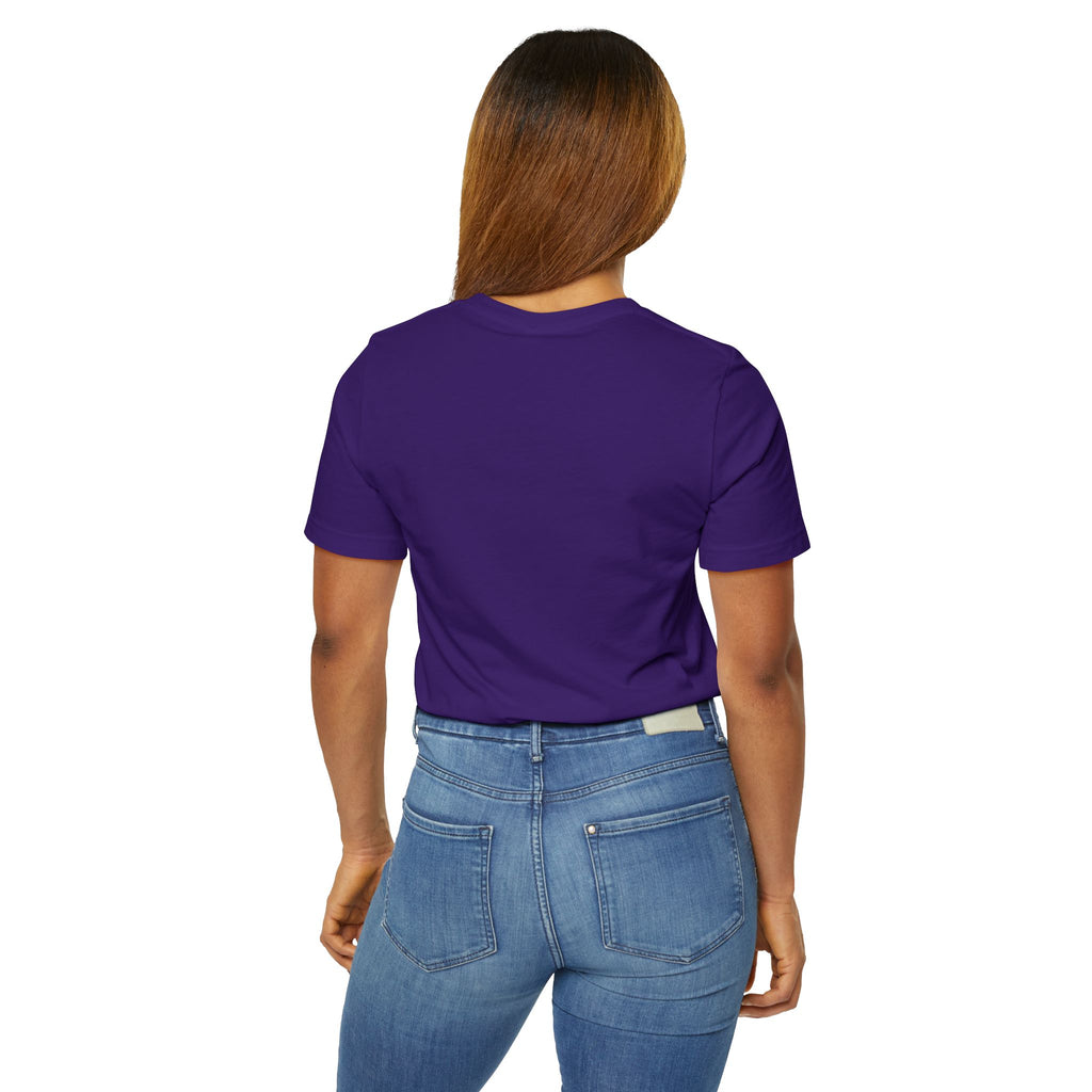 A woman with straight brown hair stands facing away, wearing the Anti Social She-Wolf T-Shirt — Funny Introvert Graphic Tee and blue jeans, with her left hand resting by her side.