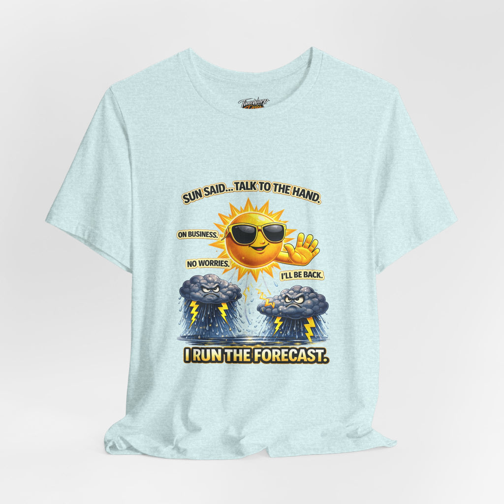 The TimeWarp Drip Calm Energy Vibes T-Shirt features a light blue, lightweight design with a smiling sun wearing sunglasses and "I Run the Forecast" CEO Energy slogan, flanked by storm clouds. Text: “SUN SAID... TALK TO THE HAND. I RUN THE FORECAST.”.