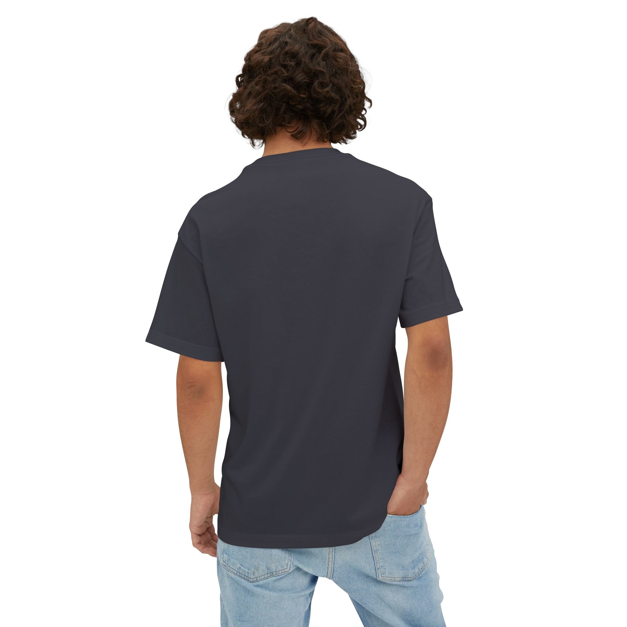 A person with curly hair is seen from behind against a white background, wearing the Crowned In Every Era - Unisex Oversized Boxy Tee in a plain dark color paired with light blue jeans.