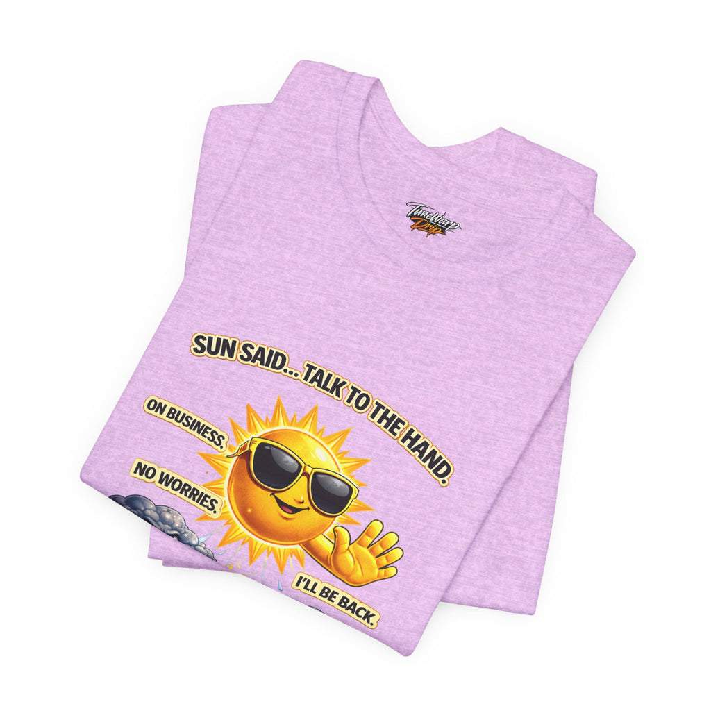 The Calm Energy Vibes T-Shirt by Printify, in light purple Airlume cotton, features a cartoon sun with CEO Energy—sunglasses on, hand up—plus the text: "SUN SAID... TALK TO THE HAND. ON BUSINESS. NO WORRIES. I’LL BE BACK," with a small cloud beside it.