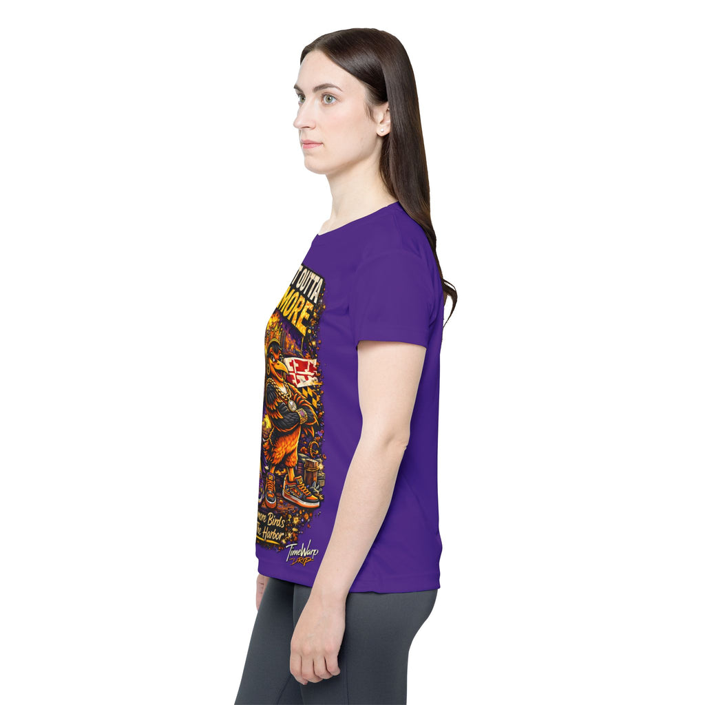 A woman with long brown hair stands in profile, wearing the purple Straight Outta Baltimore — Women's Sports Jersey with a colorful Baltimore Birds graphic and dark leggings, facing left against a white background.