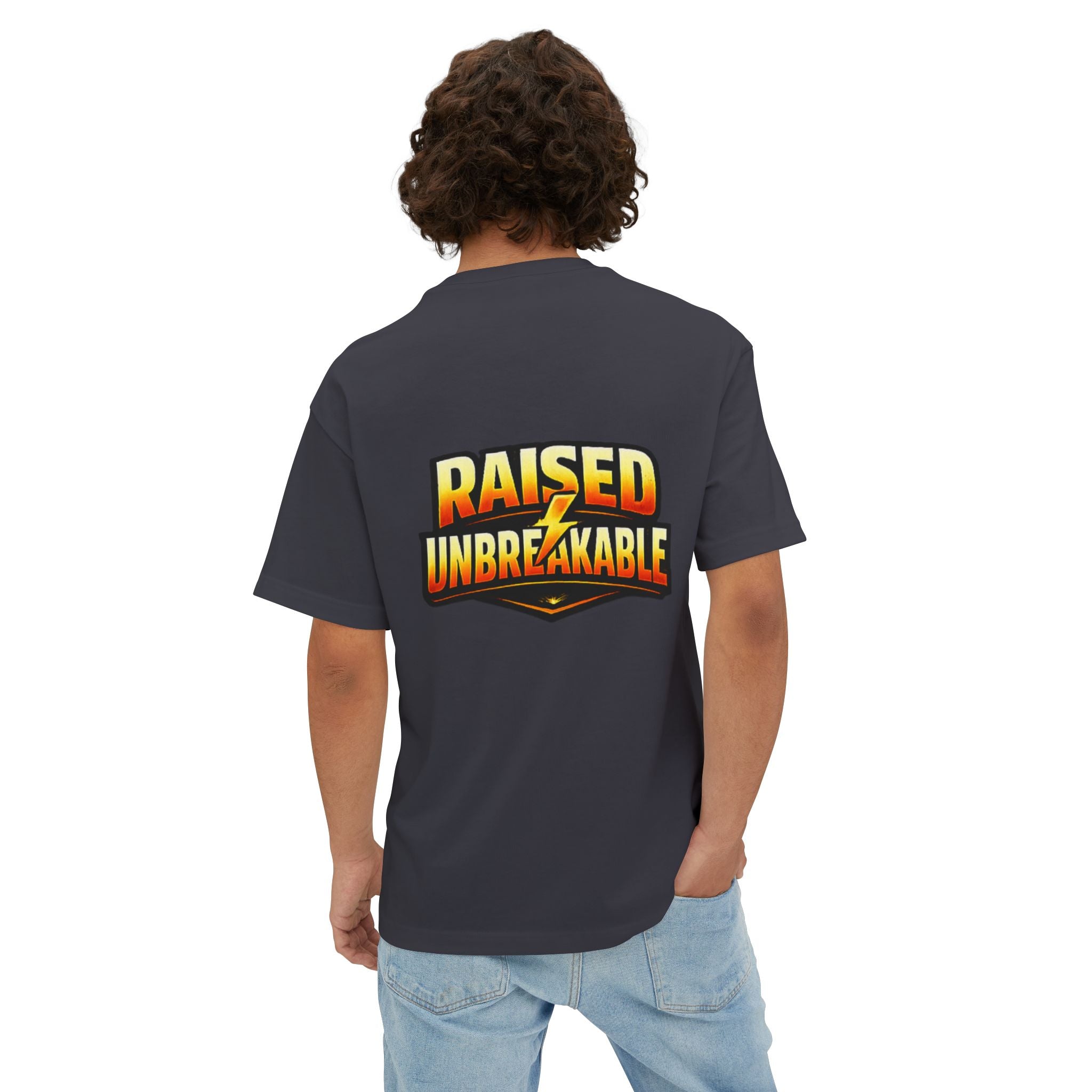 Seen from behind, a person with curly hair wears TimeWarp Drip's Generation X Parenting "Come Get Em" oversized boxy T-shirt made of breathable cotton, featuring bold yellow and orange "RAISED UNBREAKABLE" text on the back, paired with light blue jeans.
