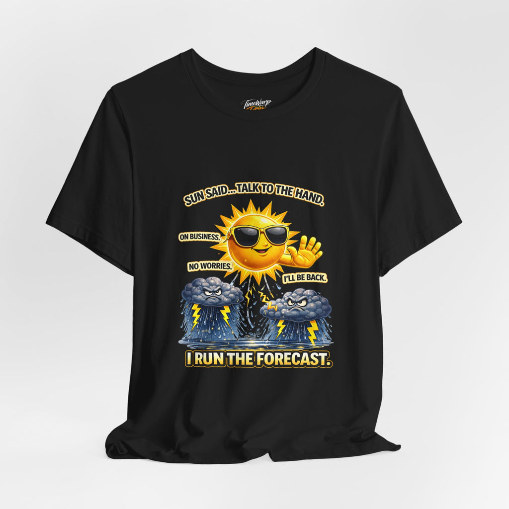 The TimeWarp Drip Calm Energy Vibes T-Shirt — "I Run the Forecast" CEO Energy is a black, lightweight Airlume cotton tee featuring a cartoon sun with sunglasses, hand raised over storm clouds. Text: Sun said... talk to the hand, I run the forecast.