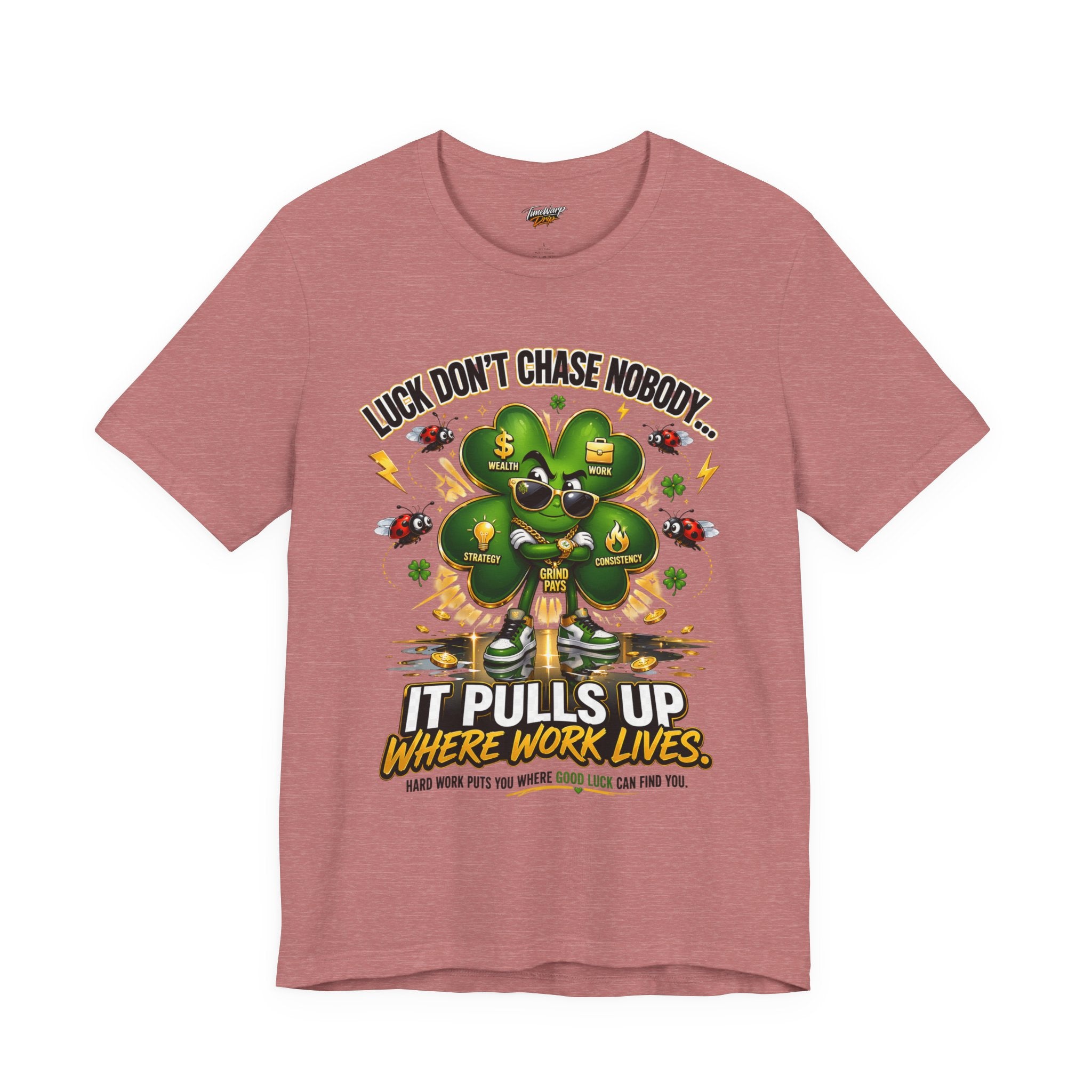 The "Lucky Clover, Pulls Up Lives" T-shirt comes in pink (sizes S–3XL) and showcases a bold green four-leaf clover with coins, dice, and horseshoes—reminding you that luck follows hard work.