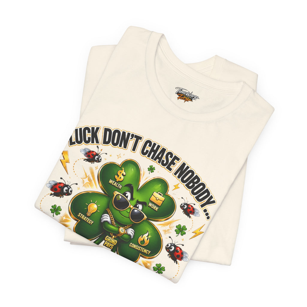 The Lucky Clover "Pulls Up Lives" Graphic T-Shirt, in sizes S–3XL, features a white folded tee with a cool cartoon shamrock in sunglasses, ladybugs, lightning bolts, and the saying LUCK DONT CHASE NOBODY.